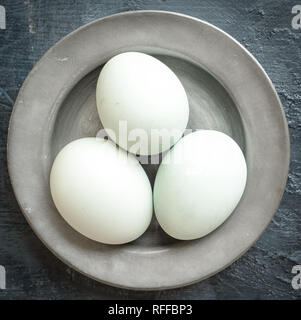 Eggs, eggshells on pewter plate Stock Photo