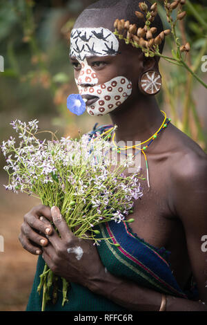 KIBISH, ETHIOPIA - AUGUST 22, 2018: unidentified woman from Surmi tribe, with flower decorations. Surmi are also called Suri or Surma and live in vill Stock Photo