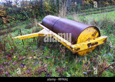 Heavy roller stored outdoors in a field - John Gollop Stock Photo