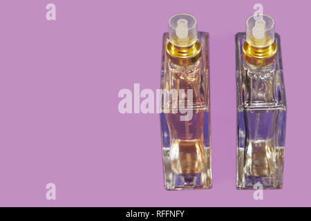 Two glass bottles with perfume on the lilac background with free copy space for text Stock Photo
