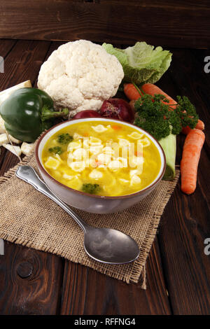 Clear soup with chicken and noodles. Broth with carrots, onions various fresh vegetables in a pot. Stock Photo