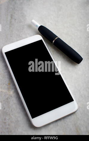 Newest electronic cigarettes, heating tobacco system and phone on table Stock Photo