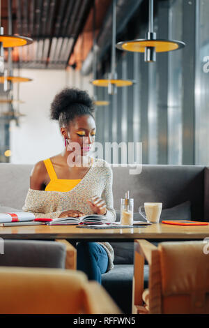 Stylish student feeling busy while studying and drinking coffee Stock Photo