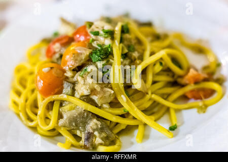 Noodles with artichokes and sea bass in Italian restaurant Stock Photo