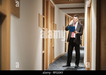 Hispanic Businessman At Work As Manager Talking On Cell Phone Stock Photo