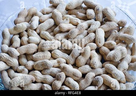 Peanuts in group on a tray of glass on table with silver cloth Stock Photo