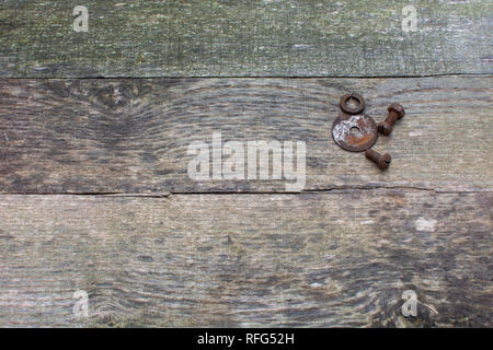 Weathered pallet wood boards as a background with rusty nuts, bolts, and washers placed in the upper right corner. Stock Photo