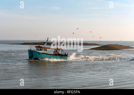 Fishing trawler LT 1020 entering the river Ore from the North Sea at Shingle Street, Suffolk, UK. Stock Photo
