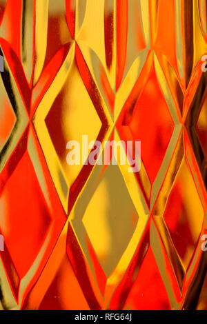 Abstract diamond textured background of a brightly colored imaged distorted through a lead crystal vase Stock Photo