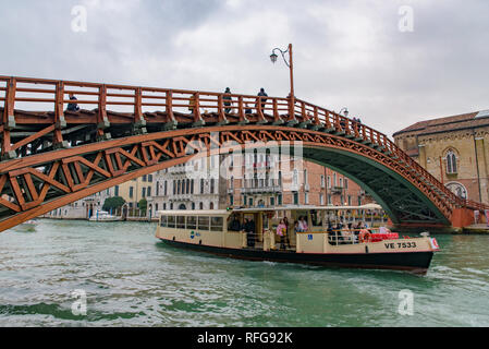 A vaporetto (waterbus) on the Grand Canal passing Accademia Bridge (Ponte dell'Accademia) in Venice, Italy Stock Photo