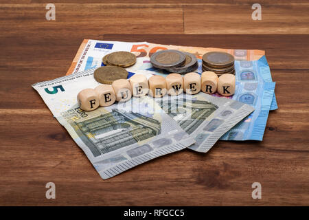 Die Euro Geldscheine und Münzen liegen auf dem Tisch mit dem Wort Feuerwerk