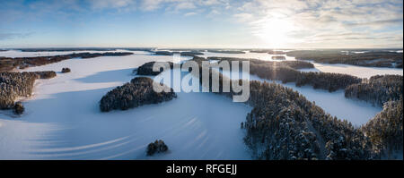 Aerial wide angle winter landscape panorama of scenic ridge road in Punkaharju, Finland. Stock Photo