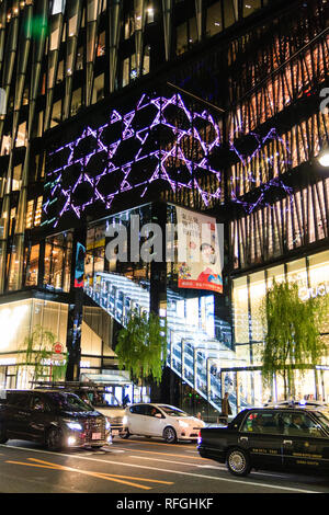 The Tokyo Ginza at night time, cars driving past the glass