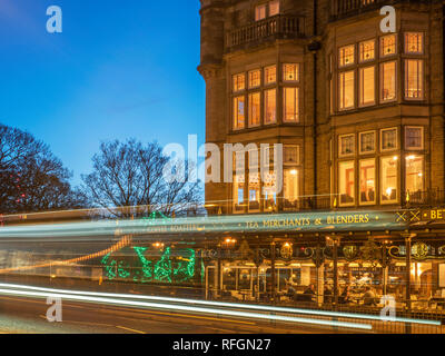 Traffic trails passing Bettys Tea Rooms at dusk from Parliament Street Harrogate North Yorkshire England Stock Photo