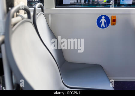 Red button STOP on the bus. Elderly (Old) People Symbol. Bus seats. New modern busses. Stock Photo