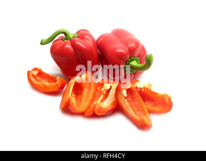 Still life with three whole and sliced red ripe bell peppers isolated on white background closeup Stock Photo