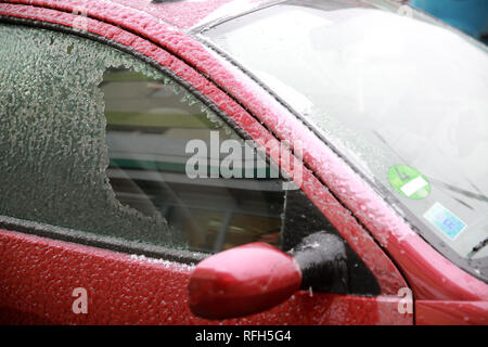 Bucharest, Romania. 25th Jan, 2019. A driver removes ice from the side window of a car in Bucharest, Romania, Jan. 25, 2019. Bucharest and many other towns in Romania were hit by freezing rain Friday, which caused great inconvenience to people's travel. Credit: Gabriel Petrescu/Xinhua/Alamy Live News Stock Photo