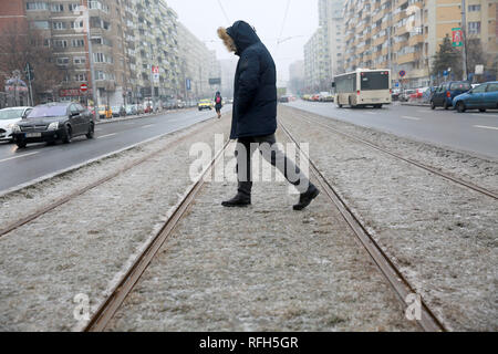 Bucharest, Romania. 25th Jan, 2019. A man walks over the grass covered with a glaze of ice in Bucharest, Romania, Jan. 25, 2019. Bucharest and many other towns in Romania were hit by freezing rain Friday, which caused great inconvenience to people's travel. Credit: Gabriel Petrescu/Xinhua/Alamy Live News Stock Photo