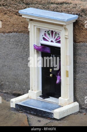 Cambridge, UK. 25th Jan, 2019. A tiny copy of the famous front door to the British Prime Minister's residence, No 10 Downing Street, London seen in Downing Street, CAMBRIDGE. Mystery Street artists going by the pseudonym of 'Dinky Doors' are responsible for the installation, which is the latest in an ongoing project. To date there are 'dinky doors' at the Reality Checker on Parker's Piece and the Teleport-O-Matic machine between red phone boxes by the Great St Mary's church in the city. Credit: SOPA Images Limited/Alamy Live News Stock Photo