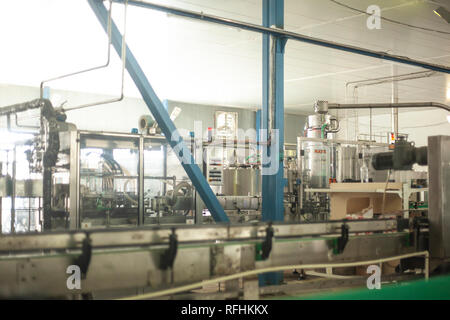 Glass bottles on the automatic conveyor line at the champagne, beer or wine factory. Plant for bottling alcoholic beverages Stock Photo