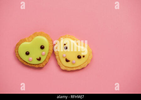 Heart shaped sugar cookies decorated with pastel royal icing on pink background. Fairy tales concept. Top view. Stock Photo