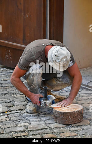 Close up of working man cutting and shaping ceramic tile with angle grinder Stock Photo