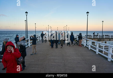 People strolling along a wooden pier stretching into the Baltic sea in Jelitkowo, Gdansk, Poland Stock Photo