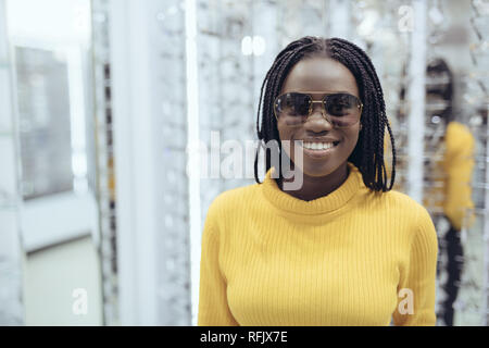 Young african woman choose sunglasses in optical store Stock Photo