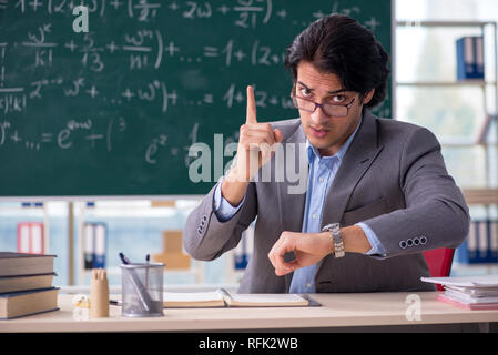 Young handsome math teacher in classroom Stock Photo