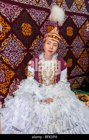 Kazakh woman in traditional attire sitting in a yurt, Alamty, Kazakhstan Stock Photo