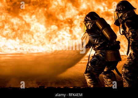 U.S. Marines with Aircraft Rescue and Firefighting (ARFF) use a hand line to extinguish a fuel fire Jan. 25, 2019 during live-burn training on Marine Corps Air Station Futenma, Okinawa, Japan. The training is held monthly to provide ARFF Marines with training scenarios to enhance their readiness to respond to any potential hazards or emergencies on the flight line. ARFF Marines entered the training area and used various hand lines, also known as a fire hose, to control and extinguish the fire. (U.S. Marine Corps photo by Lance Cpl. Nicole Rogge) Stock Photo