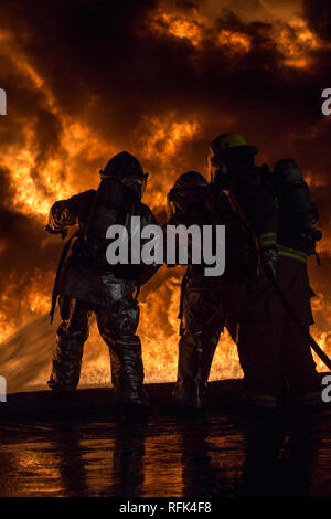 U.S. Marines with Aircraft Rescue and Firefighting (ARFF) use a hand line to extinguish a fuel fire Jan. 25, 2019 during live-burn training on Marine Corps Air Station Futenma, Okinawa, Japan. The training is held monthly to provide ARFF Marines with training scenarios to enhance their readiness to respond to any potential hazards or emergencies on the flight line. ARFF Marines entered the training area and used various hand lines, also known as a fire hose, to control and extinguish the fire. (U.S. Marine Corps photo by Lance Cpl. Nicole Rogge) Stock Photo