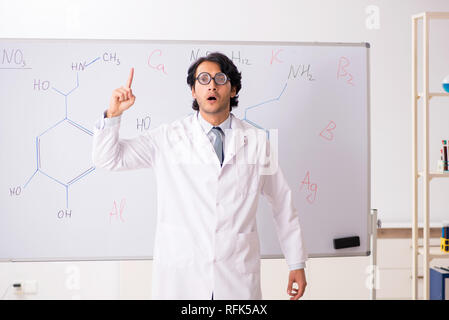 Young funny chemist in front of white board Stock Photo