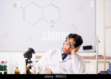 Young funny chemist in front of white board Stock Photo