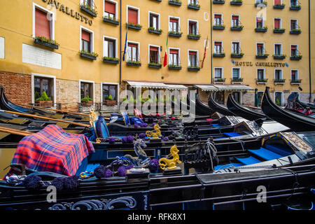 Many Gondolas, the traditional venetian rowing boats, are tied up in front of a hotel Stock Photo