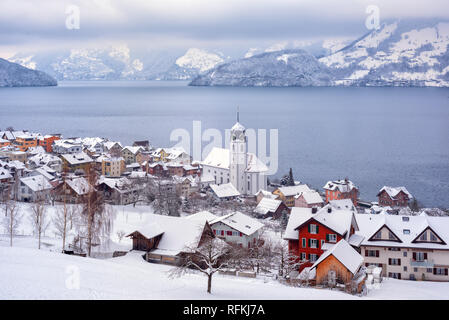 Beckenried village on Lake Lucerne, swiss Alps mountains, Switzerland, covered with white snow in winter time Stock Photo