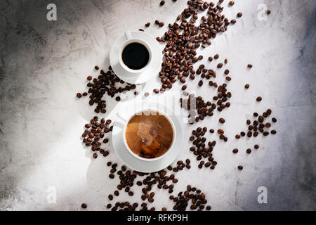 Cups of coffee with coffee beans, sun light on a marble background, top view with copy space Stock Photo