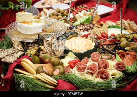 Professionally catered meat, fruits, dips, olives, cheese and crackers in a beautiful display . Holiday office party. Stock Photo