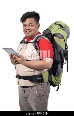 portrait of young man backpacker standing holding digital tablet Stock Photo