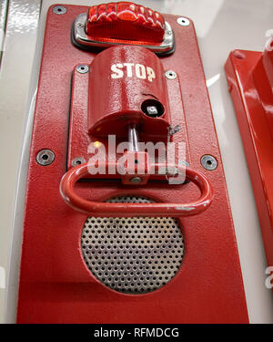 Red pull handle on wall. A emergency brake, close up. Fire alarm on platform at subway station. Stock Photo