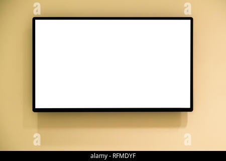 Modern blank high definition LCD flat screen TV monitor, isolated on yellow wall background Stock Photo