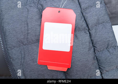 Red price tag on grey winter jacket with space for your text Stock Photo