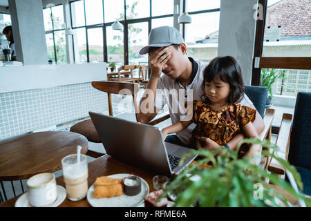 child disturb her dad while working Stock Photo