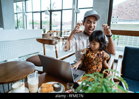 child disturb her dad while working Stock Photo