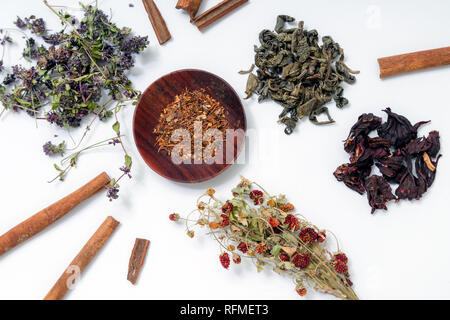 Different ding of teas on white background: green tea, red tea, thyme tea, cinnamon sticks, dried strawberries Stock Photo