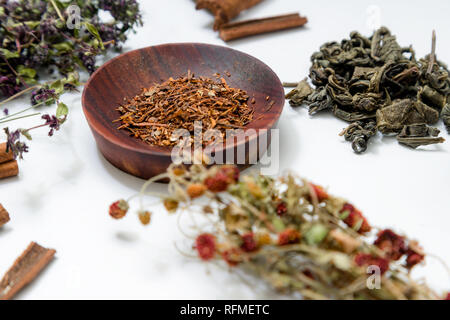 Different ding of teas on white background: green tea, red tea, thyme tea, cinnamon sticks, dried strawberries Stock Photo