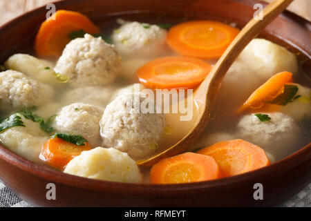 Traditional Danish Clear Chicken Soup with Meatballs and Dumplings close-up in a bowl on the table. horizontal Stock Photo