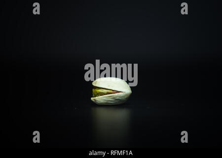 Single roasted crunchy pistachio on dark white background with space for your text Stock Photo