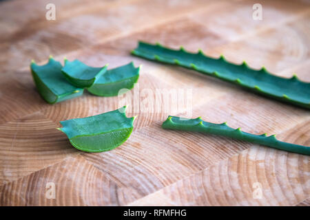 Aloe vera twigs and plant slices on wooden background Stock Photo