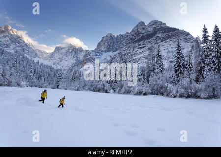 Winter outdoors can be fairytale-maker for children or even adults, mother and son hiking on snow covered mountain valley, Slovenia, Krnica valley Stock Photo